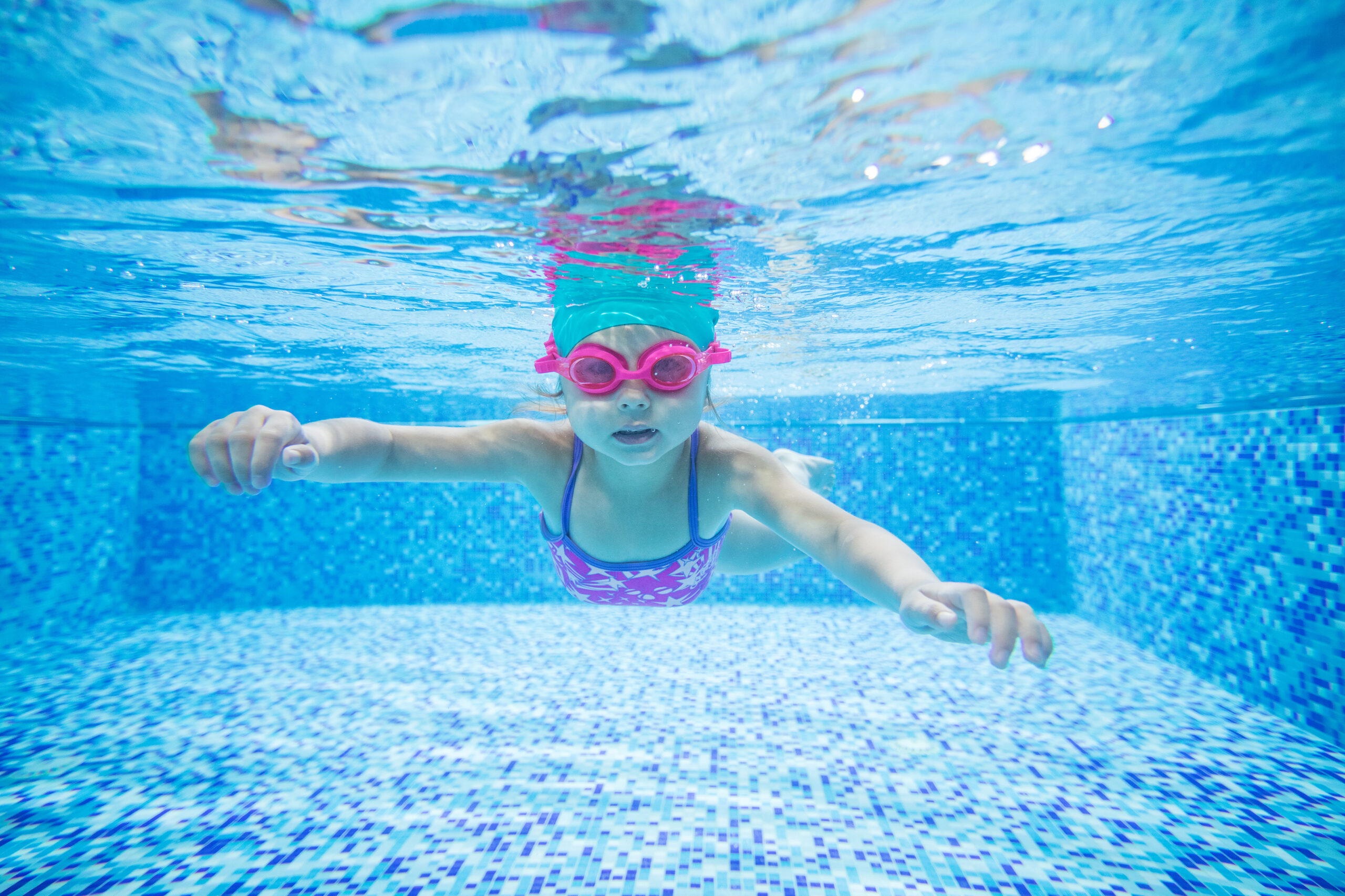 Dziewczynka w basenie, zdjęcie pod wodą