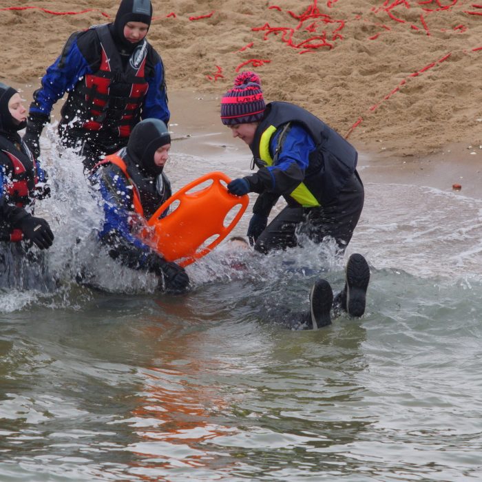 Kursanci uczą się pierwszej pomocy w wodzie na brzegu kąpieliska