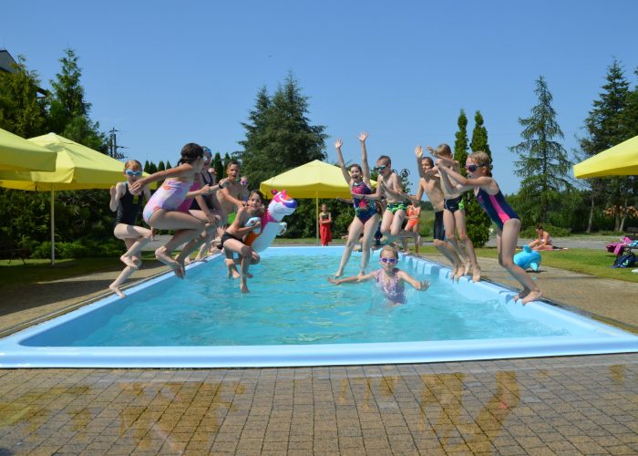 Dzieci skaczą do basenu